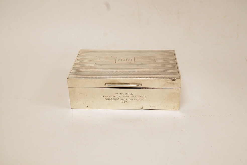 A George V silver mounted rectangular cigarette box, with later engraved inscription, Birmingham, 1932, 13.7cm, together with a similar silver vesta case and two modern silver wine labels. Condition - poor to fair